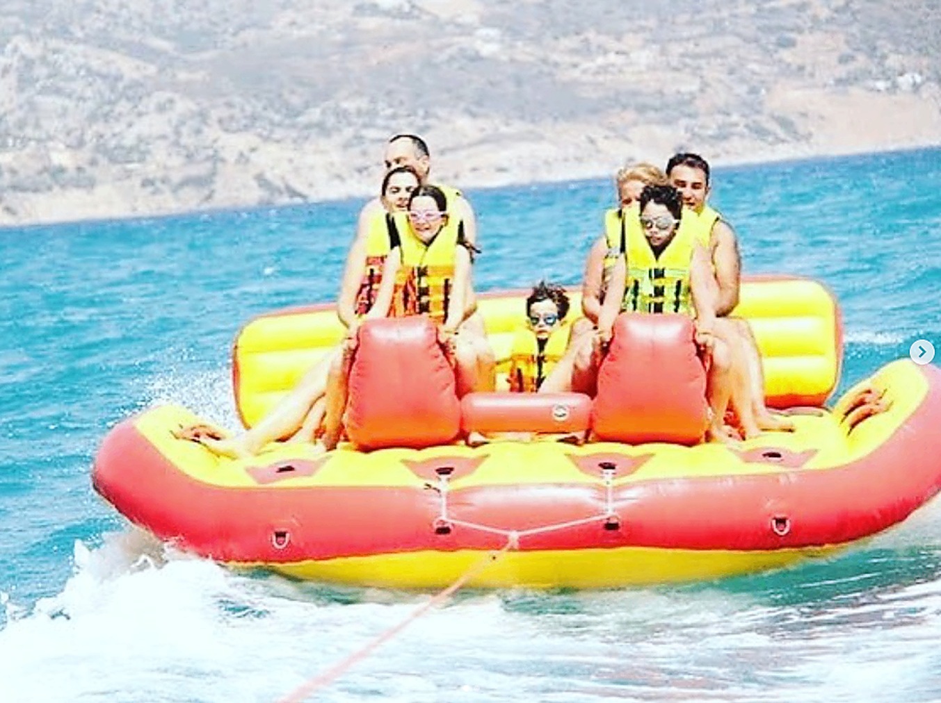 Friends riding the sofa inflatable off the Marbella coast